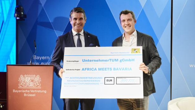 Eric Beißwenger, MdL, Bayerischer Staatsminister für Europaangelegenheiten und Internationales, überreicht einen Scheck an das Projekt „Africa meets Bavaria“.