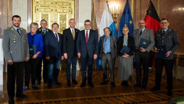 Gruppenbild zur Verleihung der Medaille für Verdienste um die Zivil-Militärische Zusammenarbeit: Staatsminister Dr. Florian Herrmann mit den geehrten Personen.