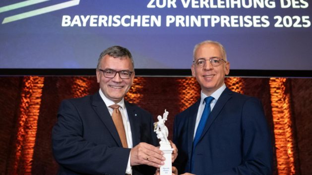 Bayerischer Printpreis 2025: Medienminister Dr. Florian Herrmann &uuml;bergibt den Ehrenpreis des Bayerischen Ministerpr&auml;sidenten an Roland Schreiner, Gesch&auml;ftsf&uuml;hrender Gesellschafter der Schreiner Group in Oberschlei&szlig;heim bei M&uuml;nchen.