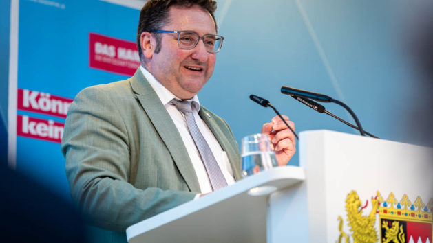 Gotthardt h&auml;lt eine Begr&uuml;&szlig;ungsrede am Rednerpult.