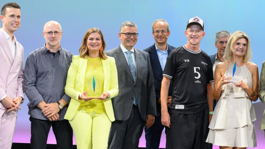 Gruppenbild nach der Verleihung der BLM-Medienpreise mit Moderator Elian Preuhs (links), Medienminister Dr. Florian Herrmann (4. von links), dem BLM-Pr&auml;sidenten Dr. Thorsten Schmiege (3. von rechts) und Preistr&auml;gern.
